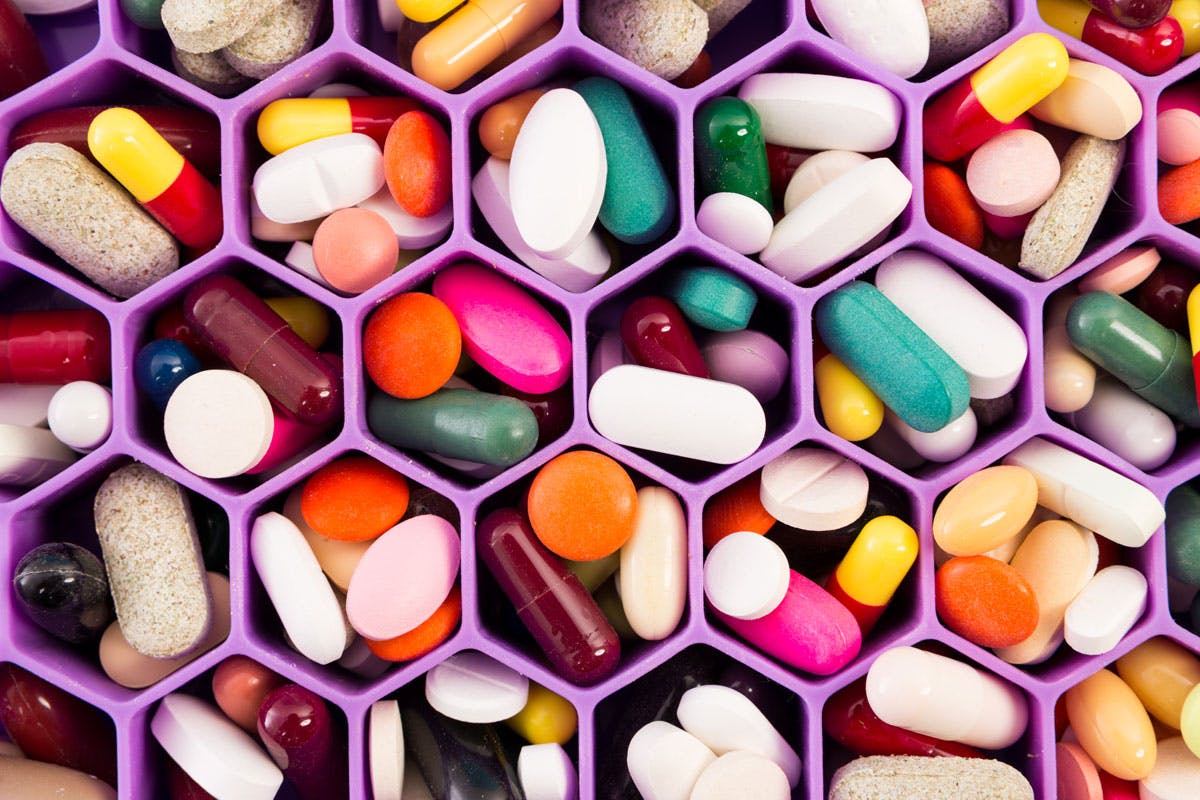 1028988046 colorful vitamin capsules on cellular comb