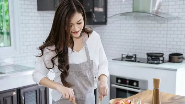 Người phụ nữ làm salad trong bếp 