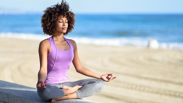 Woman meditating at beach