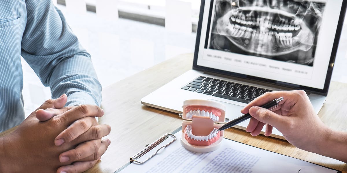 Dentist showing dentures to patient