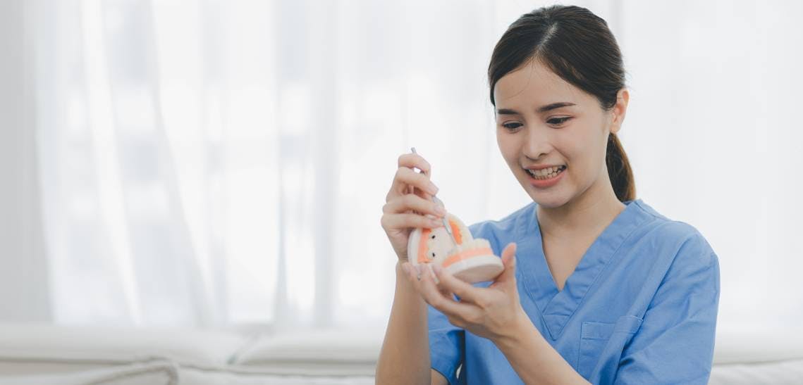 Woman holding dentures in office