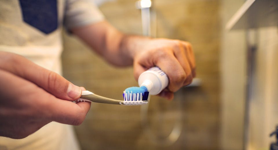 toothpaste being squeezed onto a tooth brush