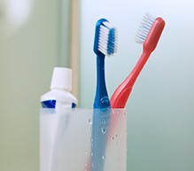 denture cleanser toothpaste and toothbrush in a holder