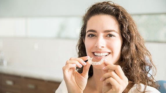 Patient holding clear dental retainer