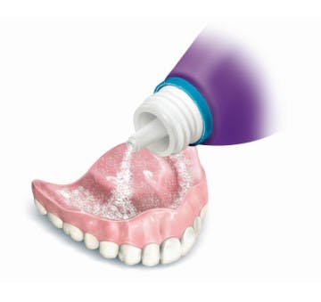 putting adhesive cream on lower dentures