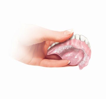 putting adhesive cream on partial dentures