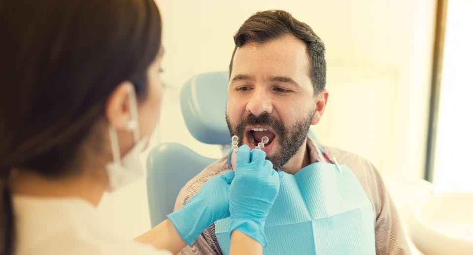 Un homme se faisant installer un appareil orthodontique par un dentiste