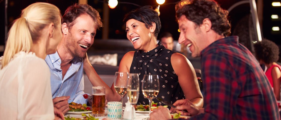un groupe d'amis riant au restaurant