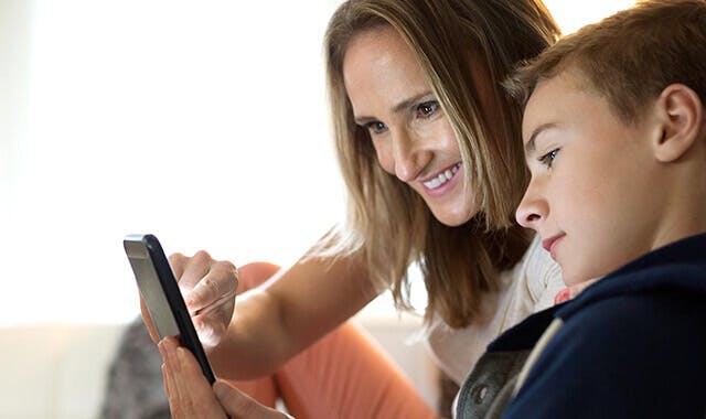 une femme et son enfant regardant un téléphone portable