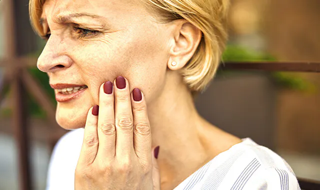 Woman has a pain in her cheeks