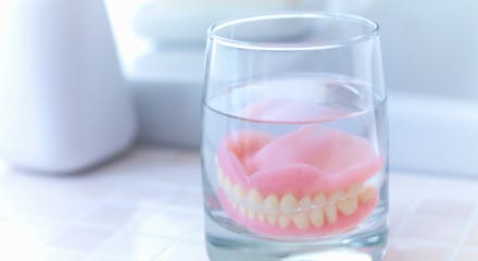 総入れ歯がコップの中に入って除菌されている