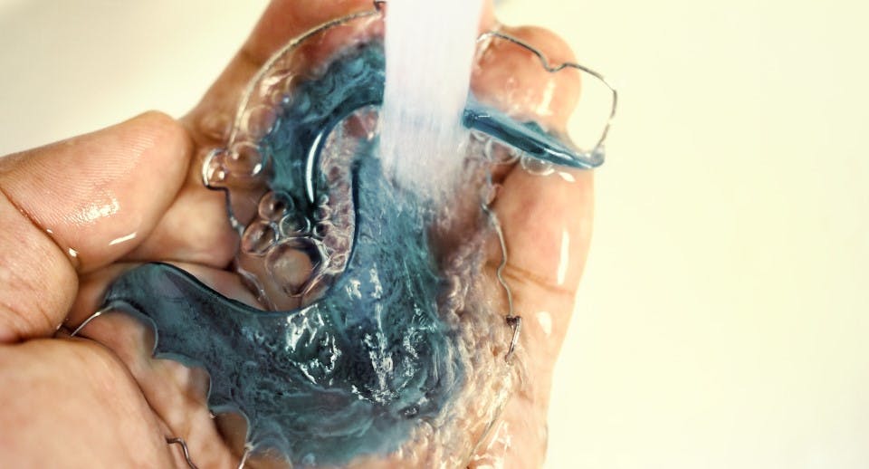 mouth guards and retainers being rinsed