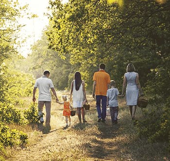 Οικογένεια με φίλους περπατούν στο δάσος