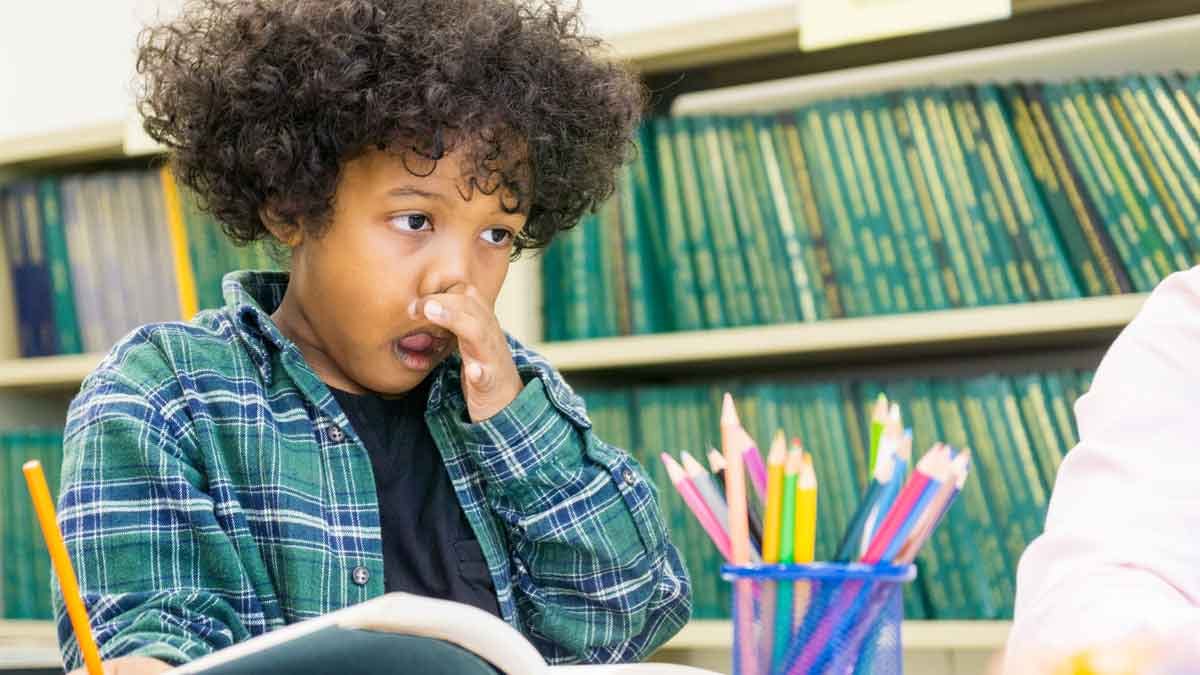 Young black boy has a stuffy nose and is wiping his nose