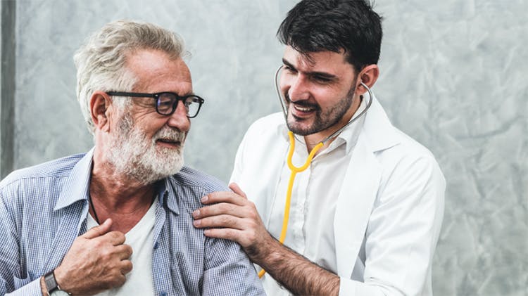 lékař mluvící se starším pacientem ho uklidňuje poklepáním po rameni