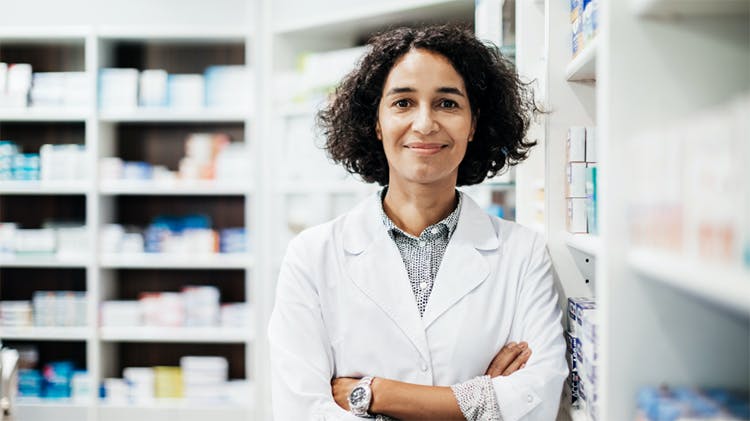 farmaceutka stojící v lékárně se usmívá