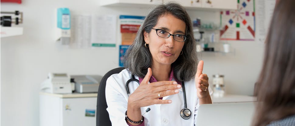 Eine Ärztin spricht mit ihrem Patienten darüber, welche Schmerzmittel zur Behandlung der Schmerzen geeignet sein könnten.