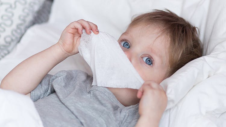 Child suffering a cold in bed