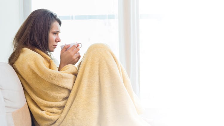 Woman in blanket unwell