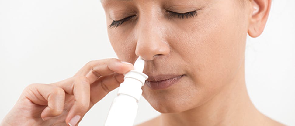 Woman using nasal spray