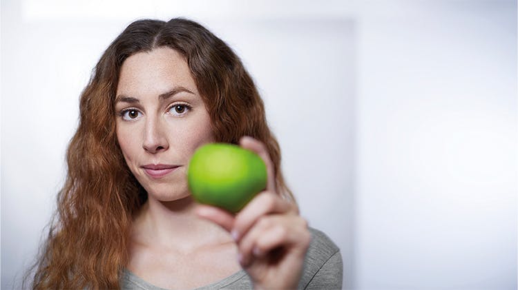 Frau mit Apfel in der Hand