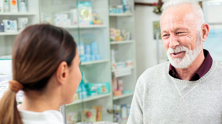 Ηλικιωμένος άνδρας ασθενής συμβουλεύεται φαρμακοποιό σχετικά με το Panadol Extra για την ανακούφιση από ημικρανίες και πόνους