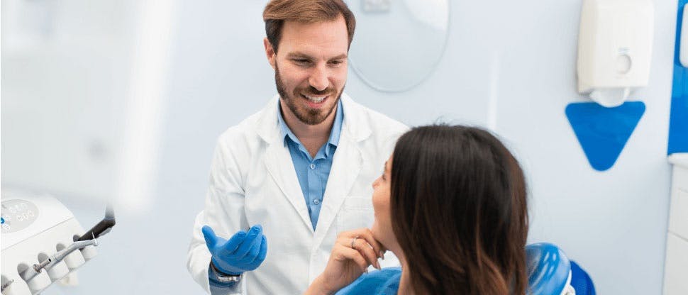 Οδοντίατρος και ασθενής εν μέσω συζήτησης