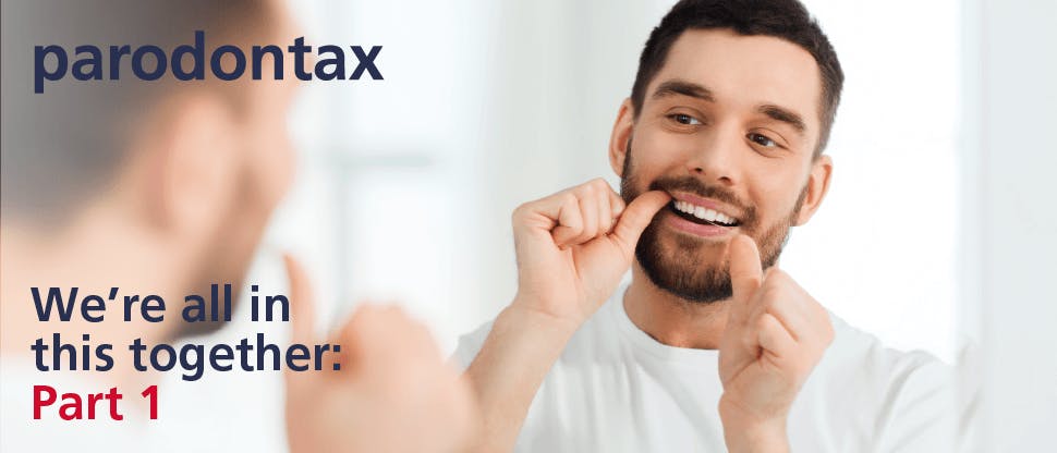 Young man with short brown hair and facial hair looks in the mirror while flossing his teeth. Text overlay says: ‘paradontax. We’re all in this together: part 1.’