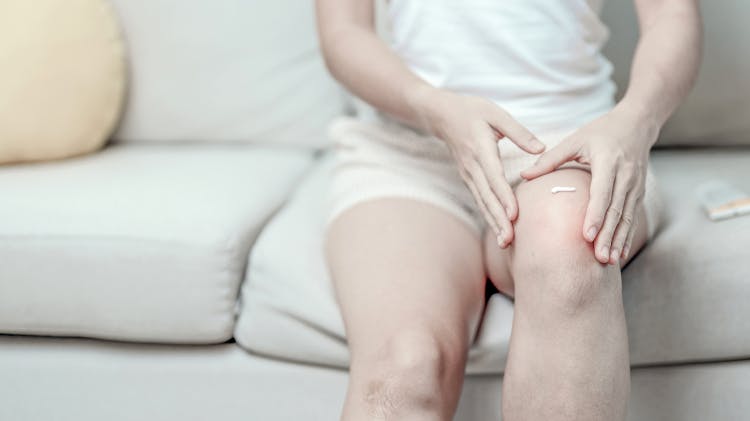 Patient applying a topical analgesic to their leg