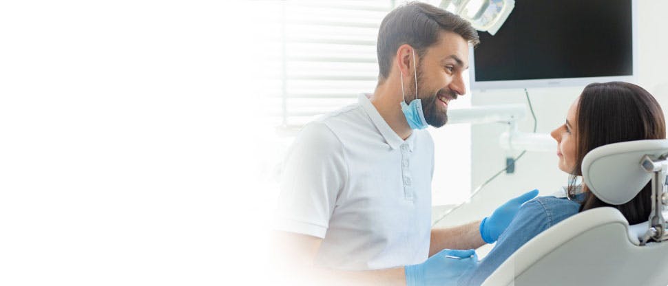 A doctor wearing a mask showing something to an woman