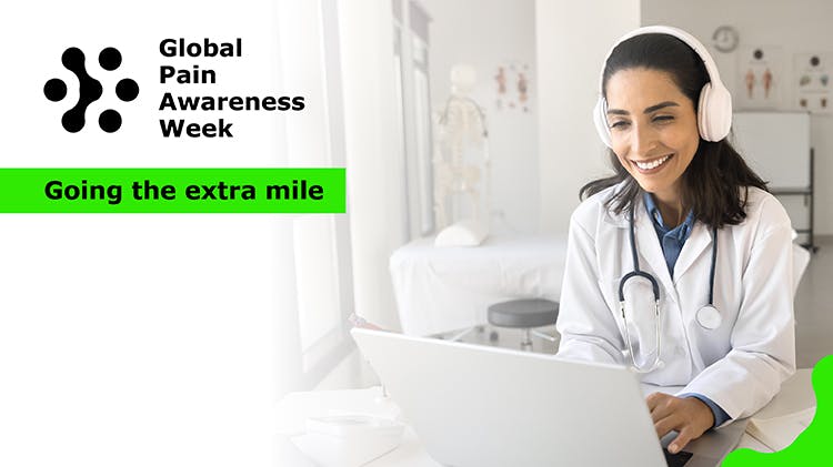 woman doctor working at laptop in hospital office, typing, smiling, using wireless headphones for video conference call.