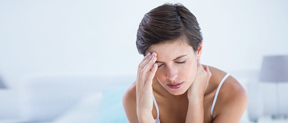 Patient with migraine holding forehead