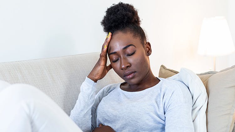 Woman touching her forehead in pain with a headache