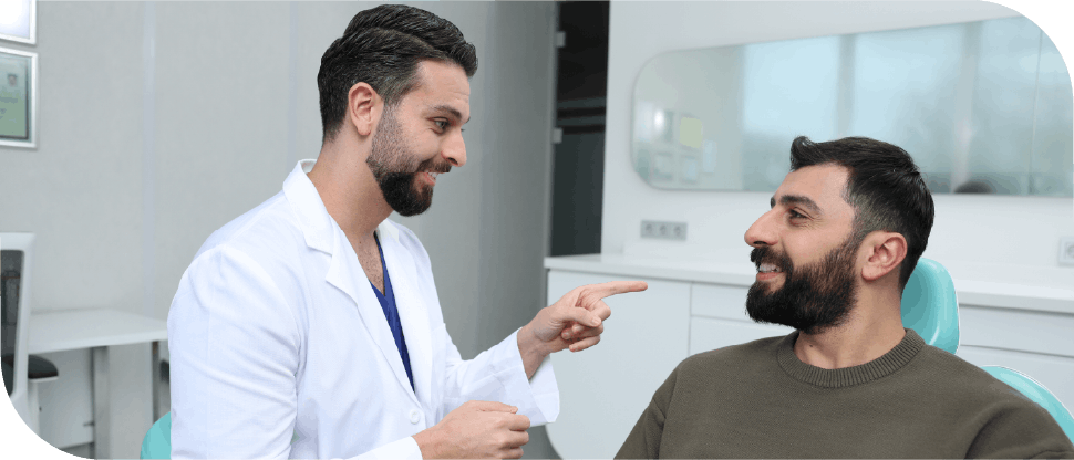 Male Arab dentist talking to male patient