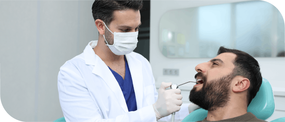 Dentist with air probe checking patient ‘s teeth (Arabic male)