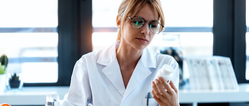 Scientist inspecting product bottle