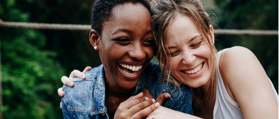 Two women hugging and laughing