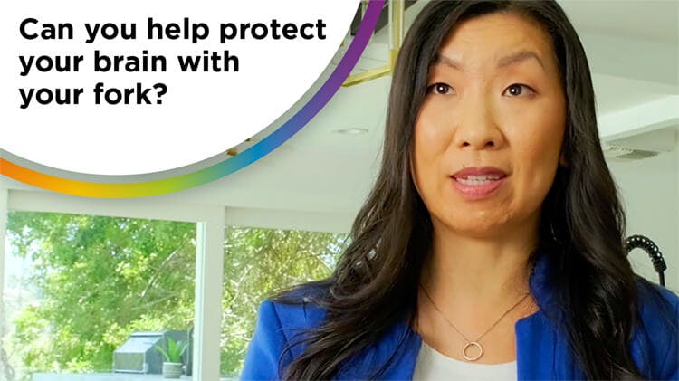 Photo of a dark-haired woman (dietitian Maggie Moon) wearing a white shirt and blue blazer with the text “can you help protect your brain with your fork?”