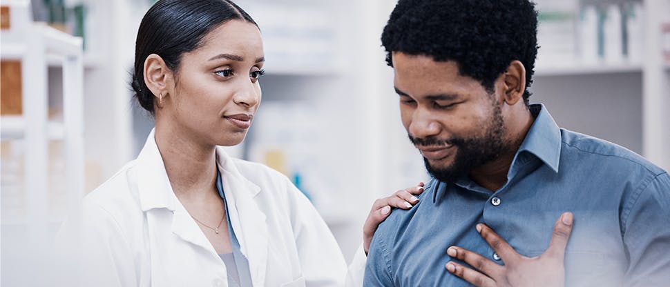 A pharmacist consoles a patient who is in pain