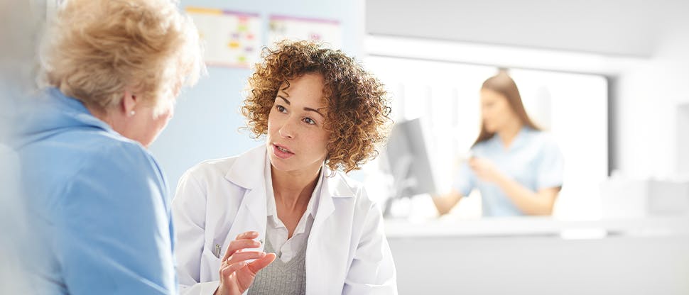 A doctor explains medical information to an older female patient