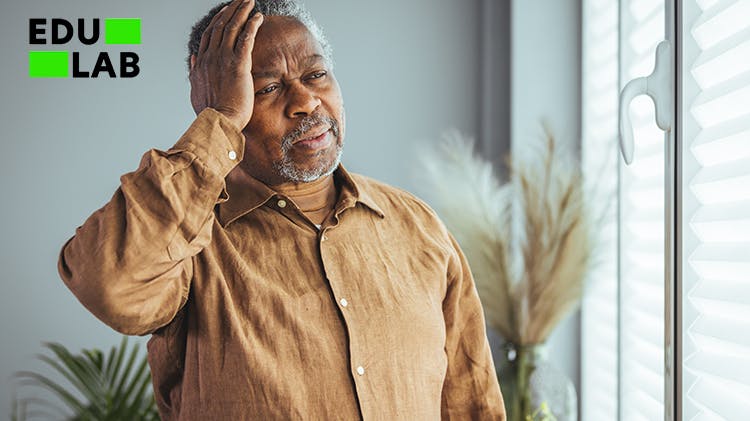 Older man holding hand to head with grimacing face