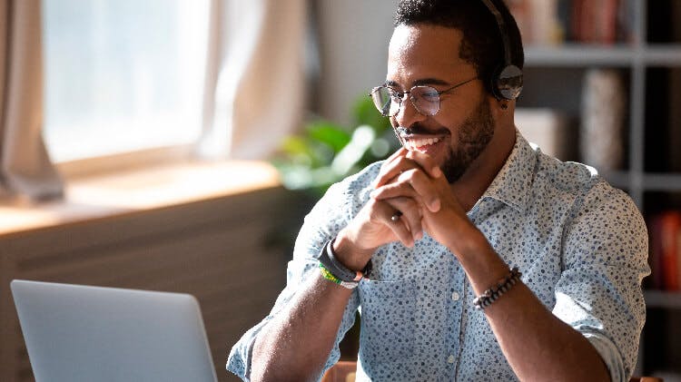 A man wearing headphone doing online call on laptop