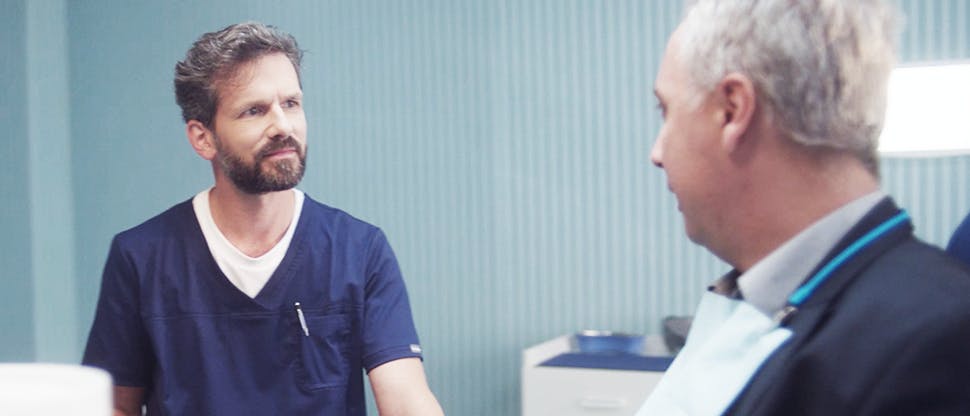 A dentist speaking with his patient