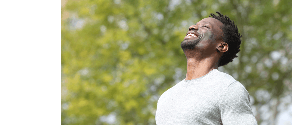 Smiling man facing the sunshine