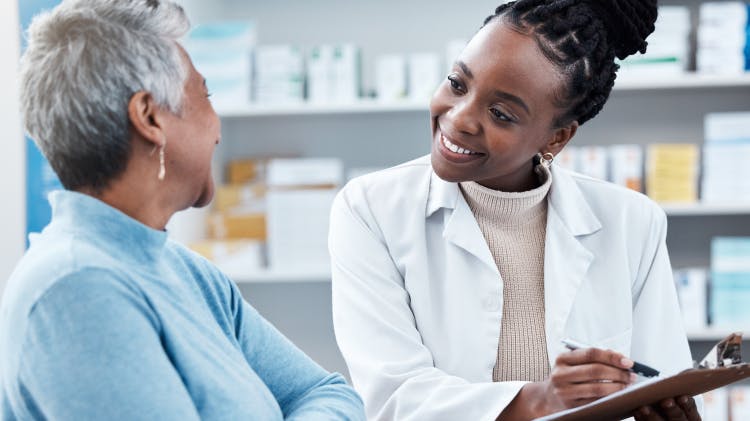 Image of a pharmacist and patient filling out a form