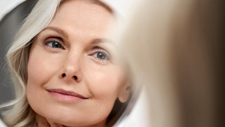 Blonde woman looking at herself in the mirror