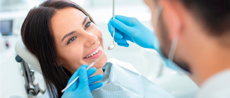 Dentist holding tools up to a patient’s mouth