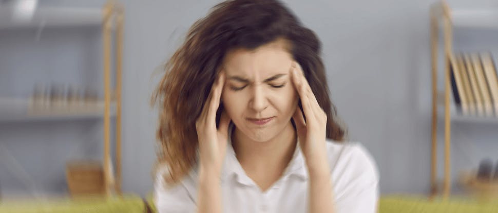 Patient with migraine holding forehead