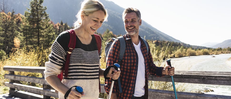 Image of a man and a woman walking through a hillside scene