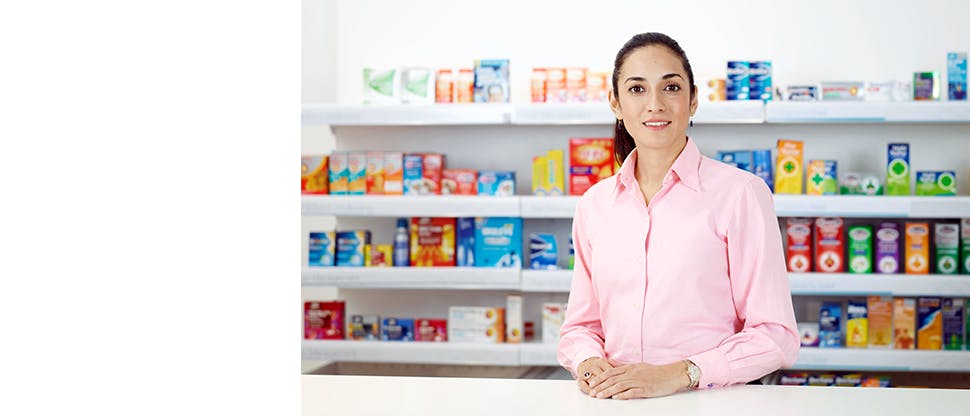 Pharmacist with pharmacy back wall